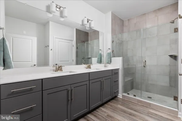 a bathroom with a double vanity sink mirror and shower