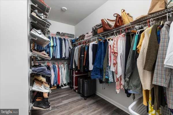 a view of walk in closet with clothes and shoes