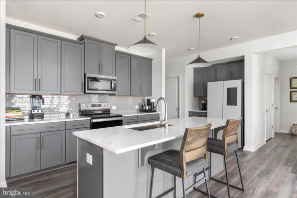 a kitchen with stainless steel appliances a stove a sink island and a refrigerator