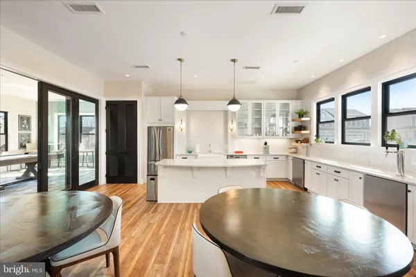 a dining room with wooden floor a chandelier a wooden table and chairs
