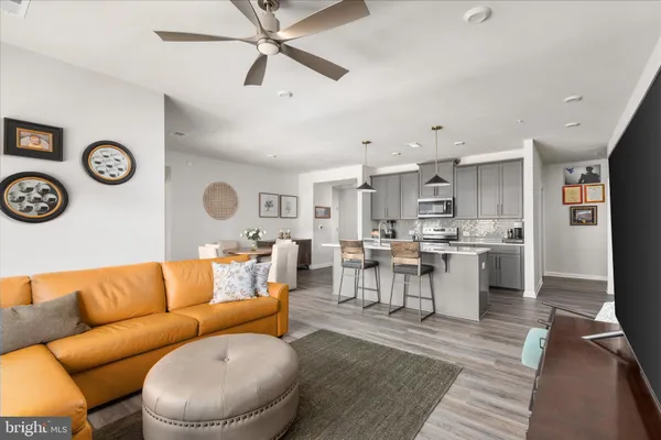 a living room with lots of furniture and view of kitchen