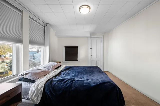 a bedroom with a bed and a large window