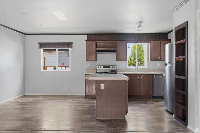 433 North 750 West Logan, UT 84321 - Photo 6 of 40 Open-concept kitchen and living area featuring wood-finish flooring, a central island, and wood cabinetry with light-toned countertops