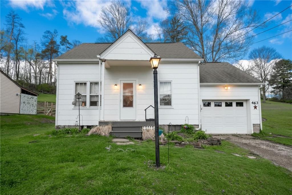 a front view of a house with a garden and yard
