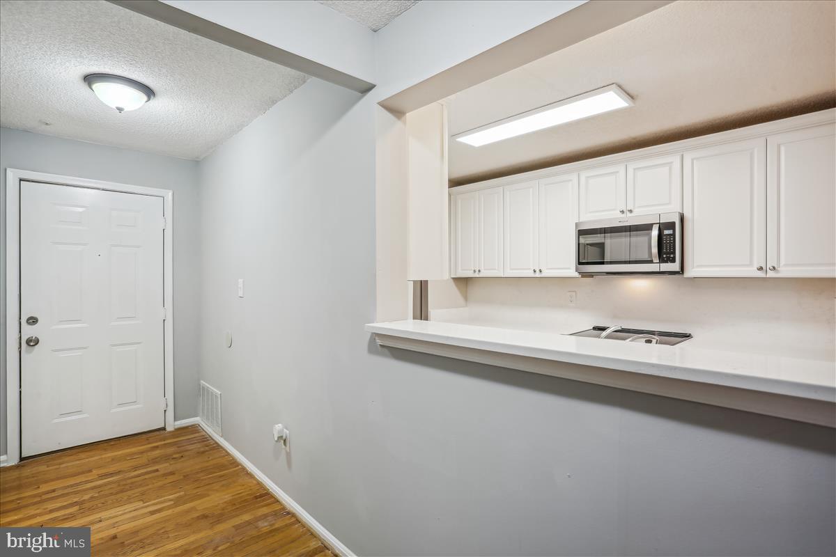 12901 Churchill Ridge Circle, Unit 14 Germantown, MD 20874 - Photo 26 of 46 a kitchen with granite countertop a stove and a microwave