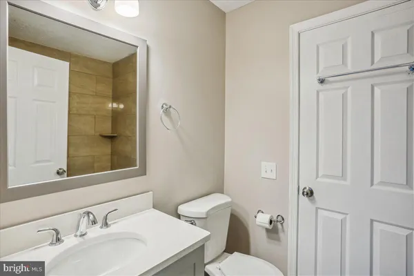 a bathroom with a sink vanity mirror and toilet