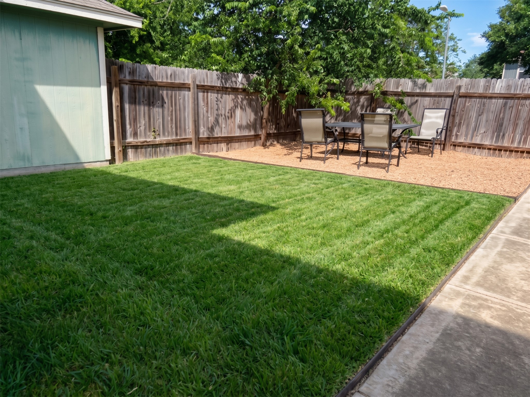 4625 Credo Lane Austin, TX 78725 - Photo 27 of 34 Lush green lawn and a gravel seating area define this fully fenced outdoor space.