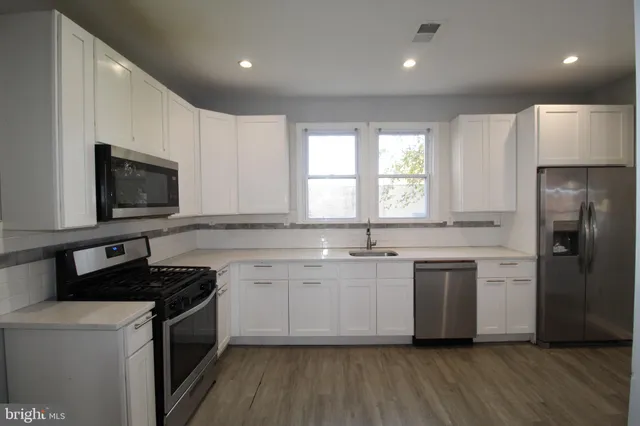 a kitchen with a sink stove and microwave