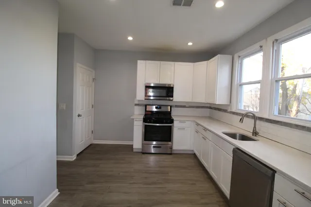 a kitchen with granite countertop a stove and a sink