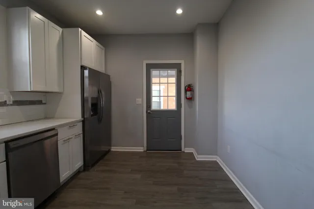 a kitchen with stainless steel appliances granite countertop a refrigerator and a stove top oven
