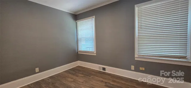 a view of a room with wooden floor and a window