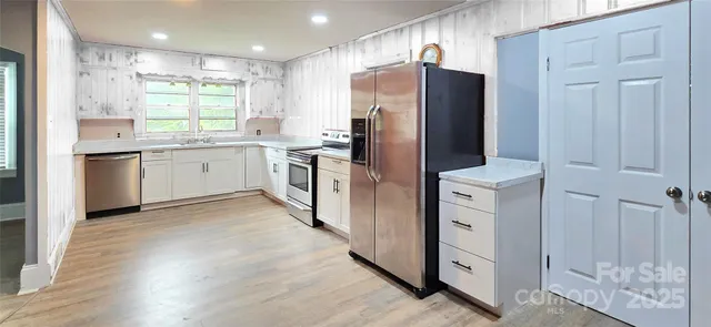 a kitchen with stainless steel appliances a refrigerator sink and cabinets