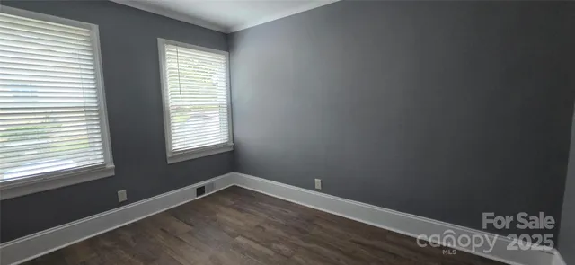 a view of a room with wooden floor and windows
