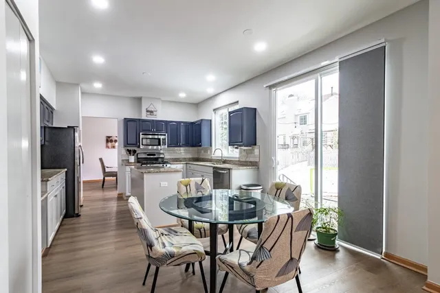 a view of a dining room with furniture a kitchen and chandelier