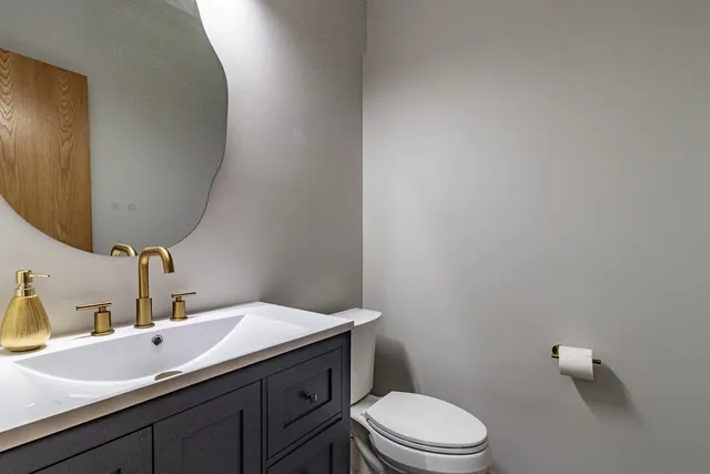a bathroom with a sink a toilet and mirror