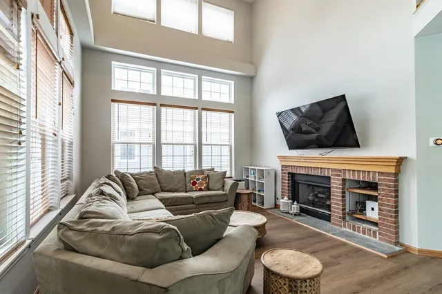 a living room with furniture a fireplace and a large window