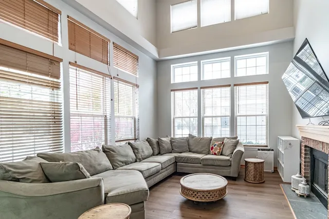 a living room with furniture a fireplace and a large window