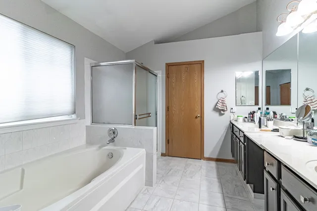 a bathroom with a tub sink and mirror
