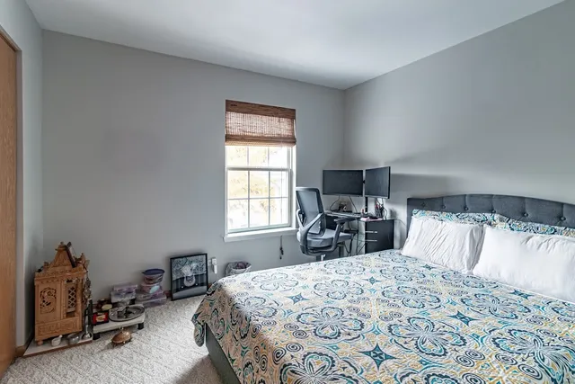 a bedroom with a bed a table and chair