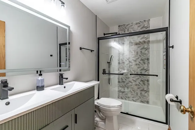 a bathroom with a sink mirror toilet and shower