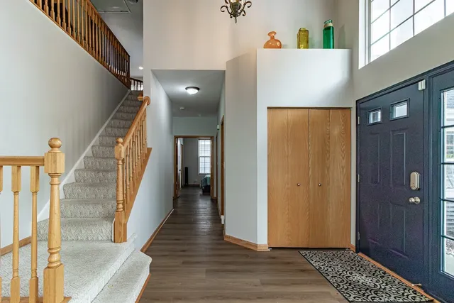 a view of a hallway with wooden floor and staircase