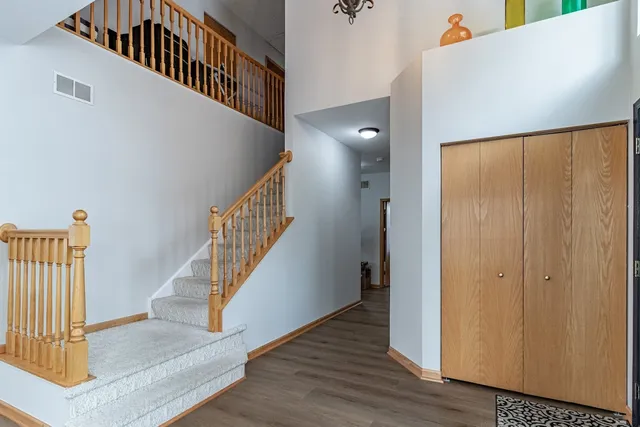 a view of staircase with wooden floor and fan