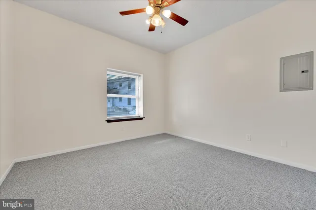 an empty room with chandelier fan