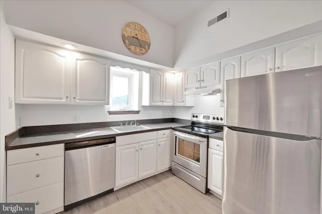 a kitchen with white cabinets and white stainless steel appliances