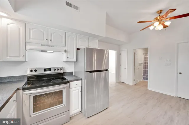 a kitchen with refrigerator a stove a sink and cabinets