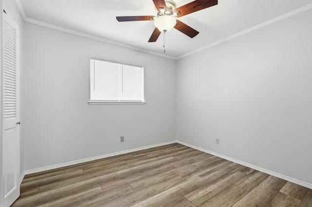 an empty room with a window and a ceiling fan