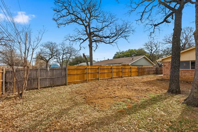 a view of a yard with wooden fence