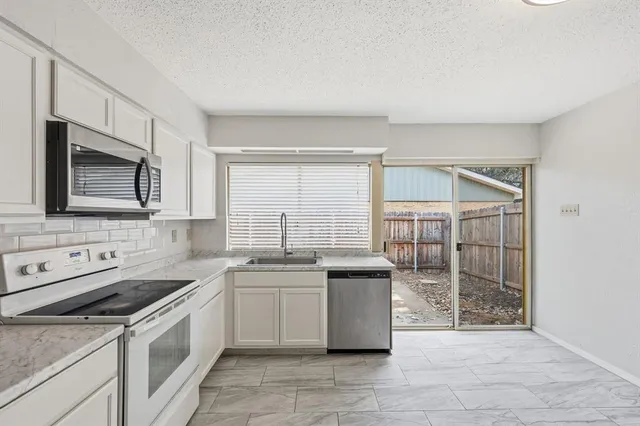 a kitchen with stainless steel appliances a sink stove and cabinets