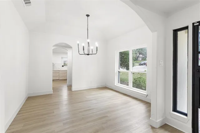 a view of empty room with wooden floor and window