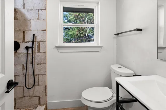 a white toilet sitting next to a bathroom sink