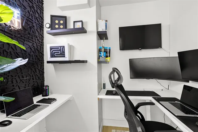 a view of a workspace with furniture and a flat screen tv