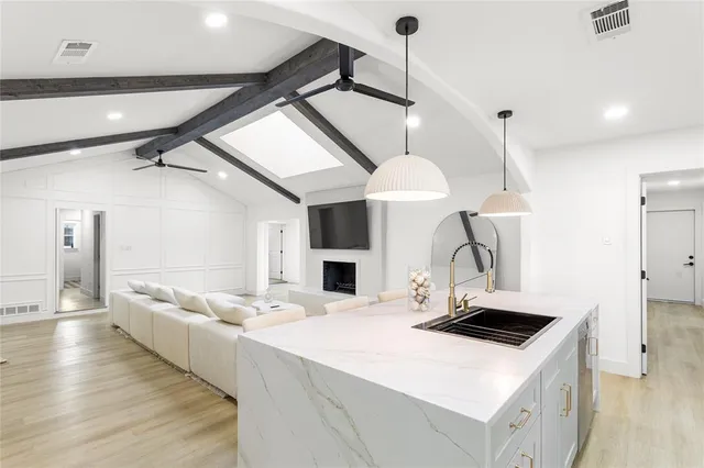 a kitchen with stainless steel appliances a stove a sink and a refrigerator