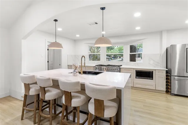 a large kitchen with a table chairs refrigerator and microwave