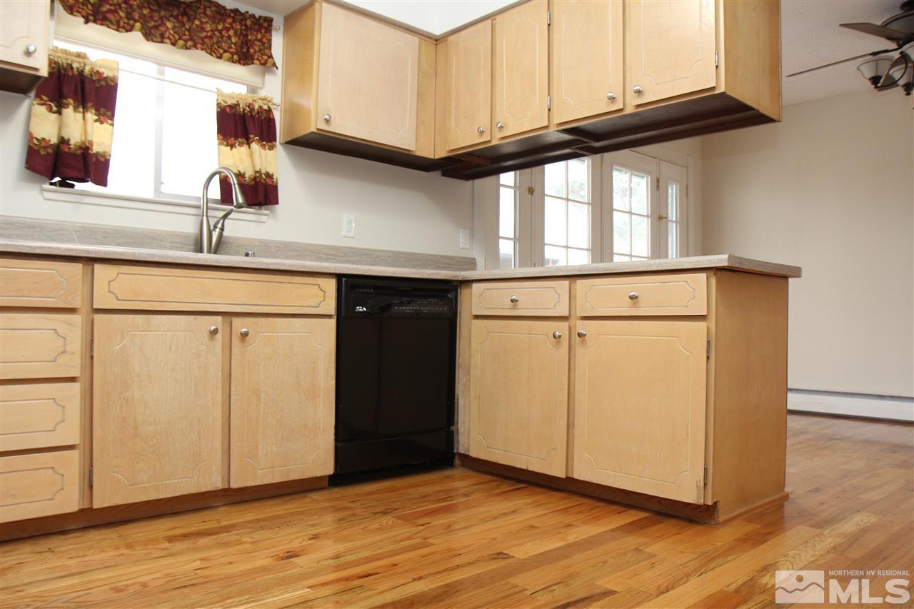 14170 Rim Rock Drive Reno, NV 89521 - Photo 9 of 25 a kitchen with granite countertop white cabinets and a wooden floor