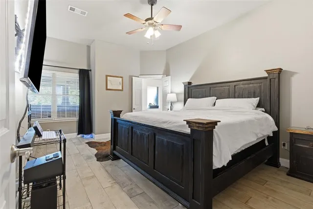 a bedroom with a bed and a flat tv screen on the dresser