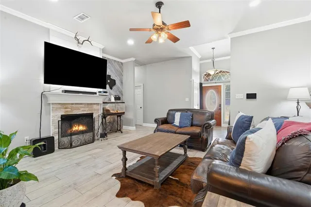 a living room with furniture a flat screen tv and a fireplace