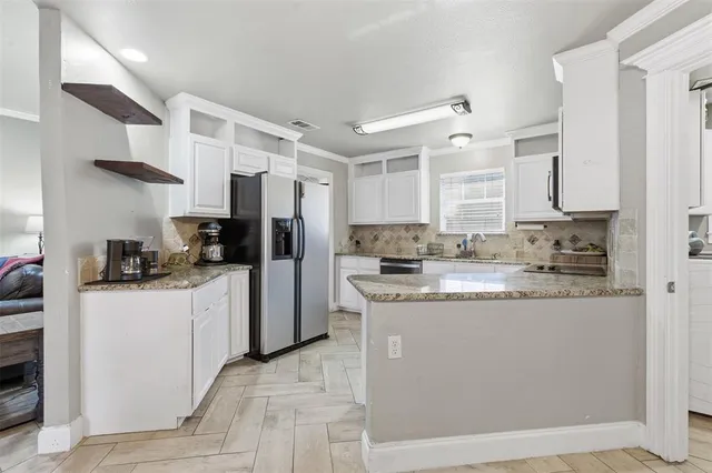 a kitchen with stainless steel appliances granite countertop a stove a sink and a refrigerator