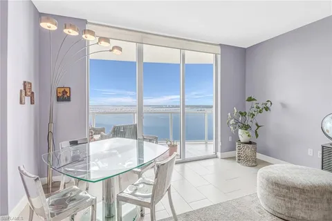 a dining room with furniture and a potted plant