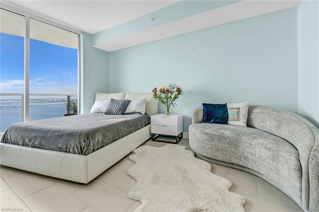 3000 Oasis Grand Boulevard, Unit 2205 Fort Myers, FL 33916 - Photo 17 of 42 a bedroom with a large bed and a couch