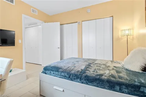 a bedroom with a large bed and a flat screen tv