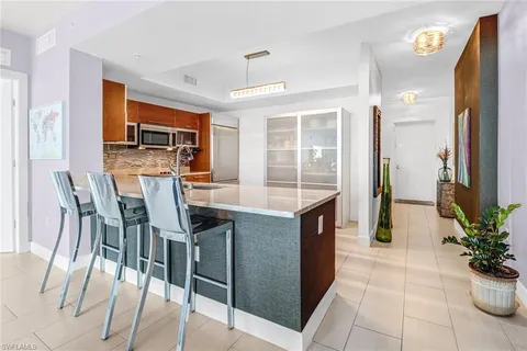 a open kitchen with stainless steel appliances kitchen island granite countertop a table and chairs in it