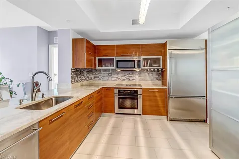 a kitchen with stainless steel appliances granite countertop a sink and a refrigerator