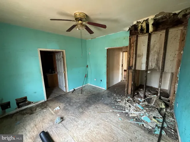 a view of a hallway with a refrigerator and a mirror