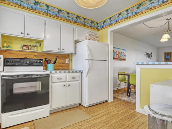 a kitchen with a refrigerator a stove and a wooden floor