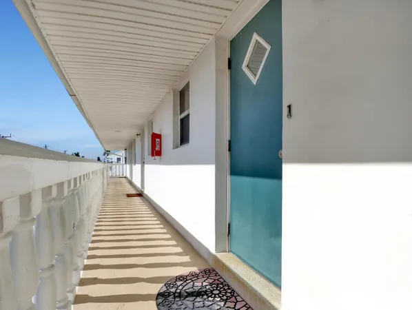 a hallway with wooden floor and stairs