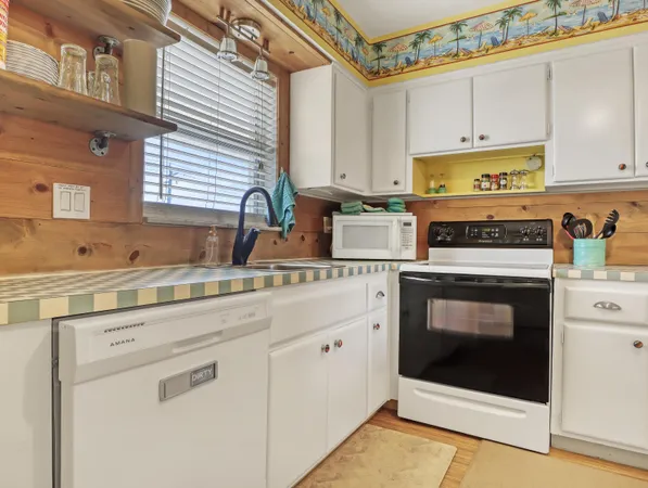 a kitchen with stainless steel appliances granite countertop a stove a sink and white cabinets